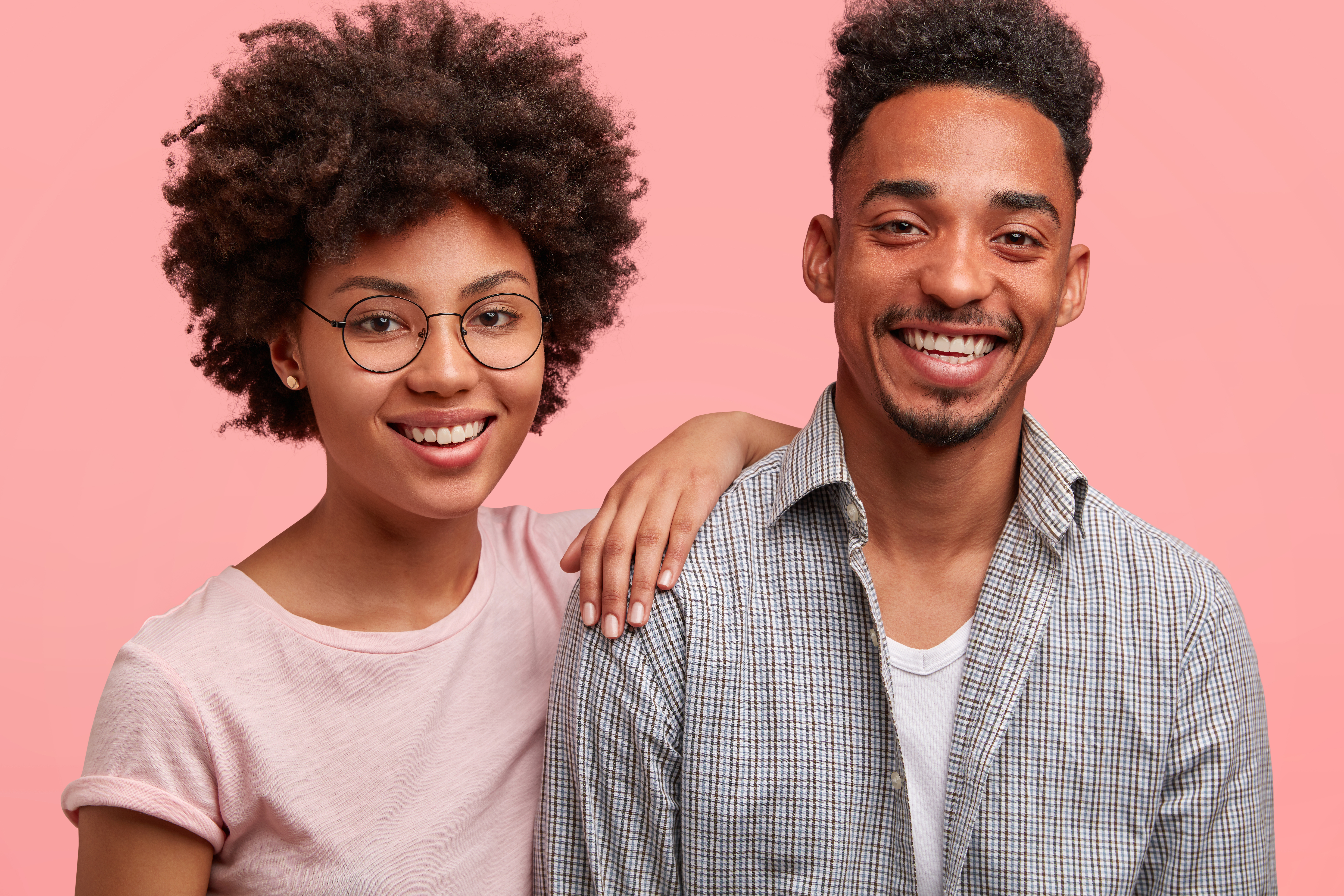 Happy Black woman and man smiling together in a bright portrait.